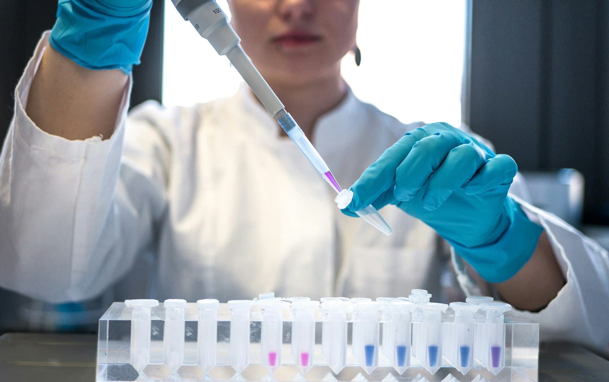 Técnica de laboratório manipulando amostras com pipeta