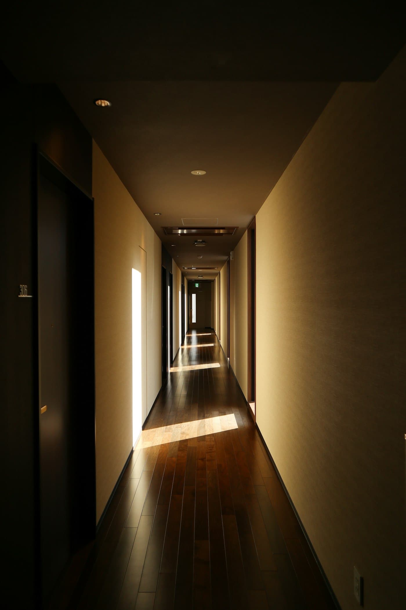 Corredor longo com luz natural entrando pelas janelas laterais